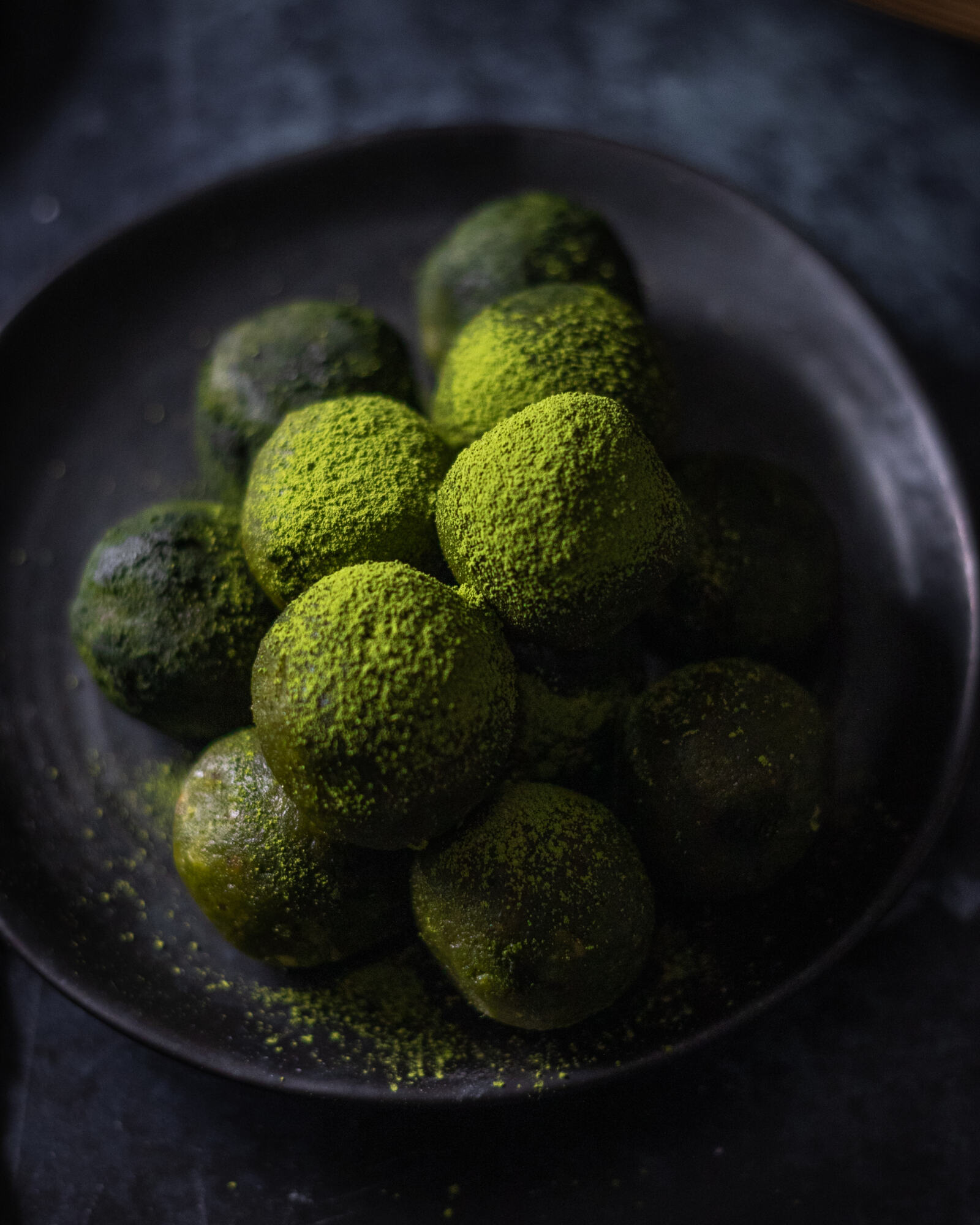 matcha powder sprinkled on top of energy balls