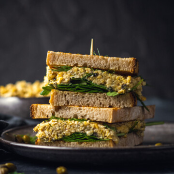 2 chickpea tuna sandwiches on top of each other on a black plate