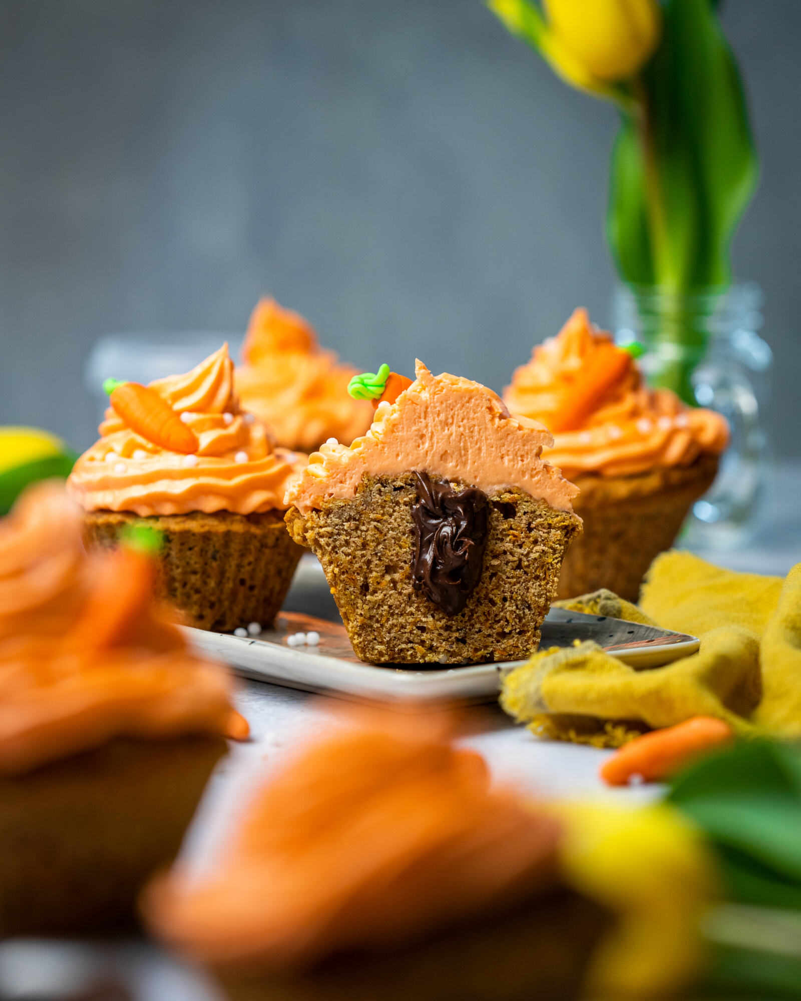 A carrot cake muffin sliced in half with a chocolate centre