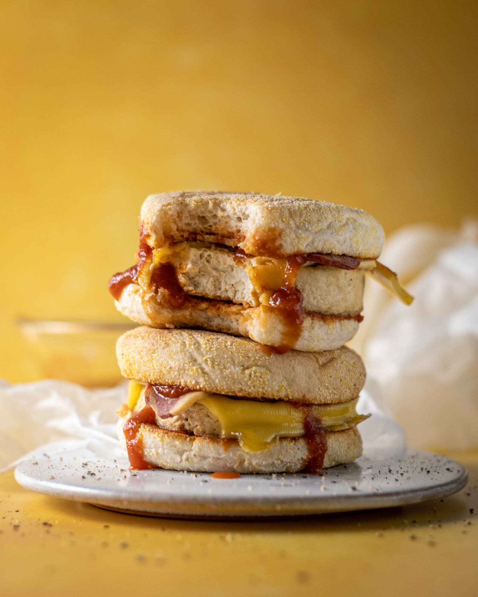 2 stacked breakfast muffins with a bite taken out of the top one