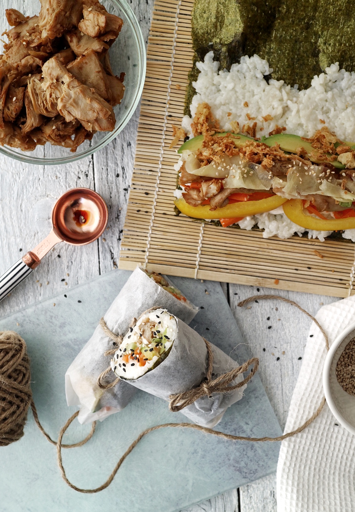 a sushi burrito on a serving board next to a sushi mat