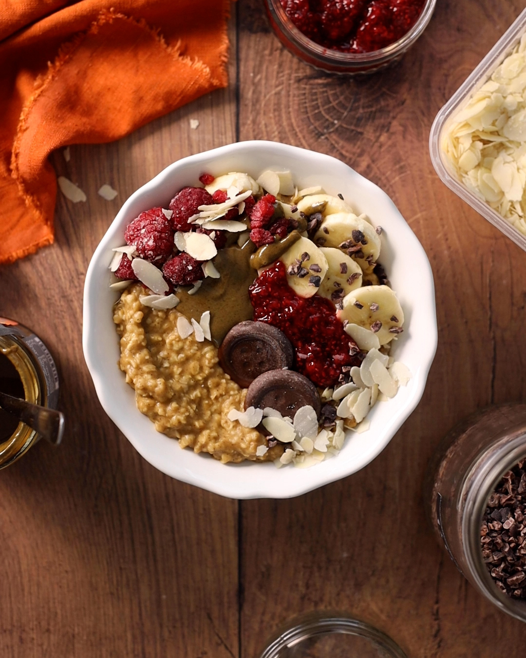 a bowl full of seasonal pumpkin spice porridge on a natural wooden table, surrounded by ingredients