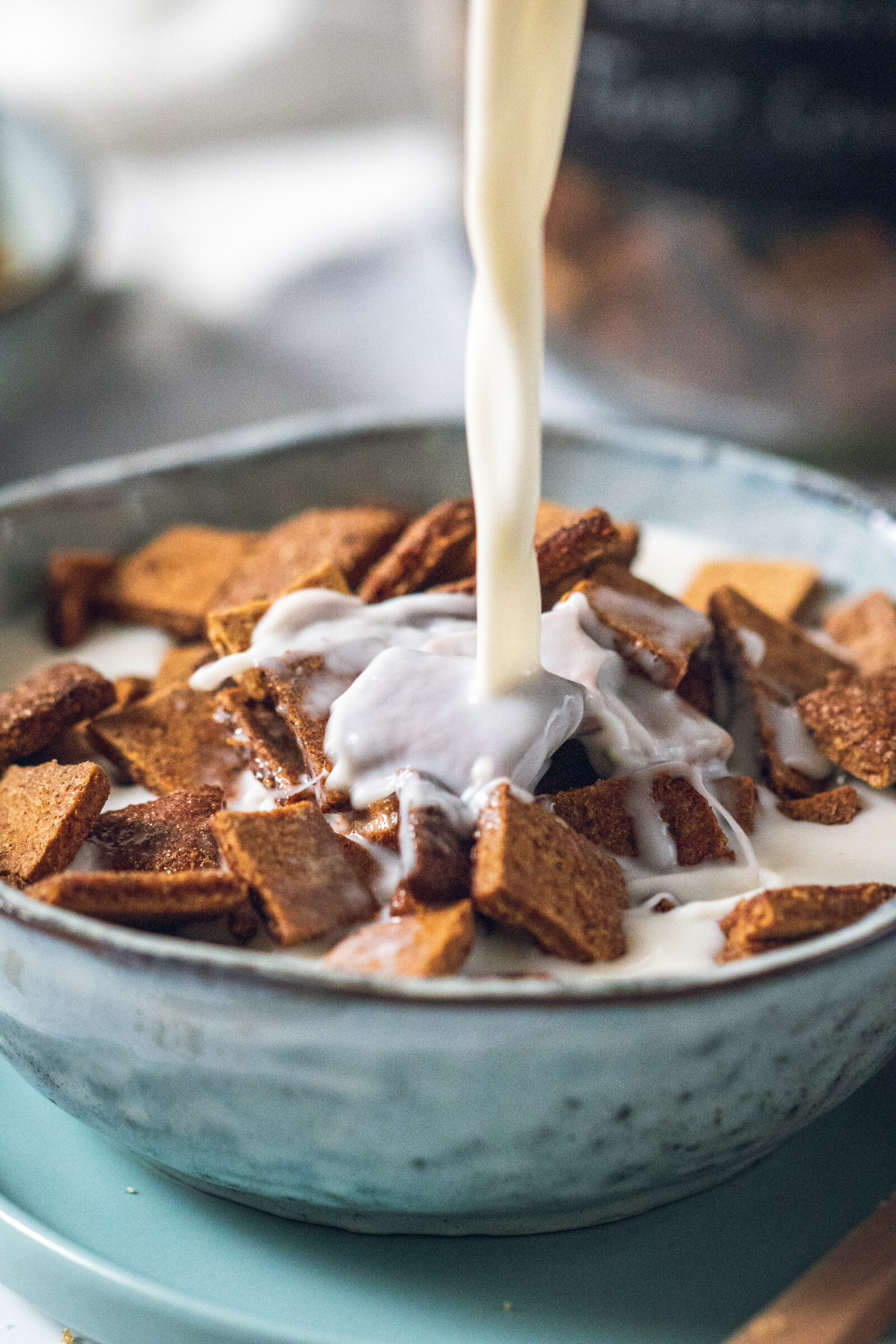 milk being poured onto a bowl of cinnamon toast crunch cereal