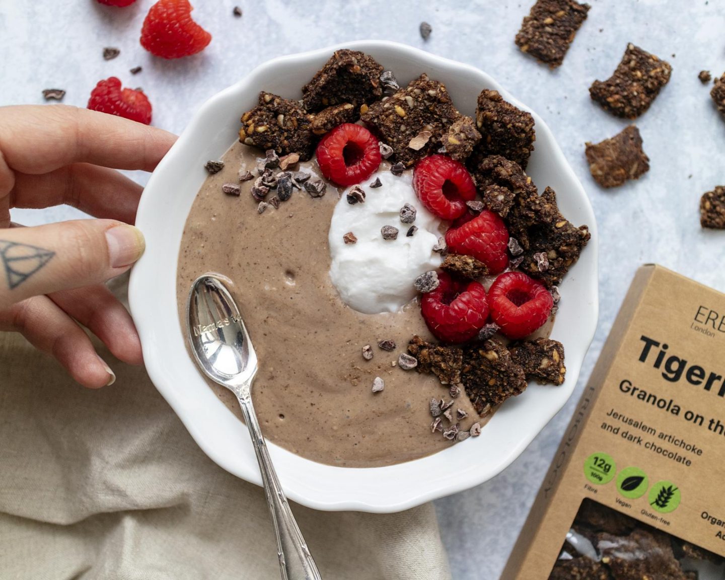 a chocolate protein smoothie bowl topped with yogurt and fresh raspberries