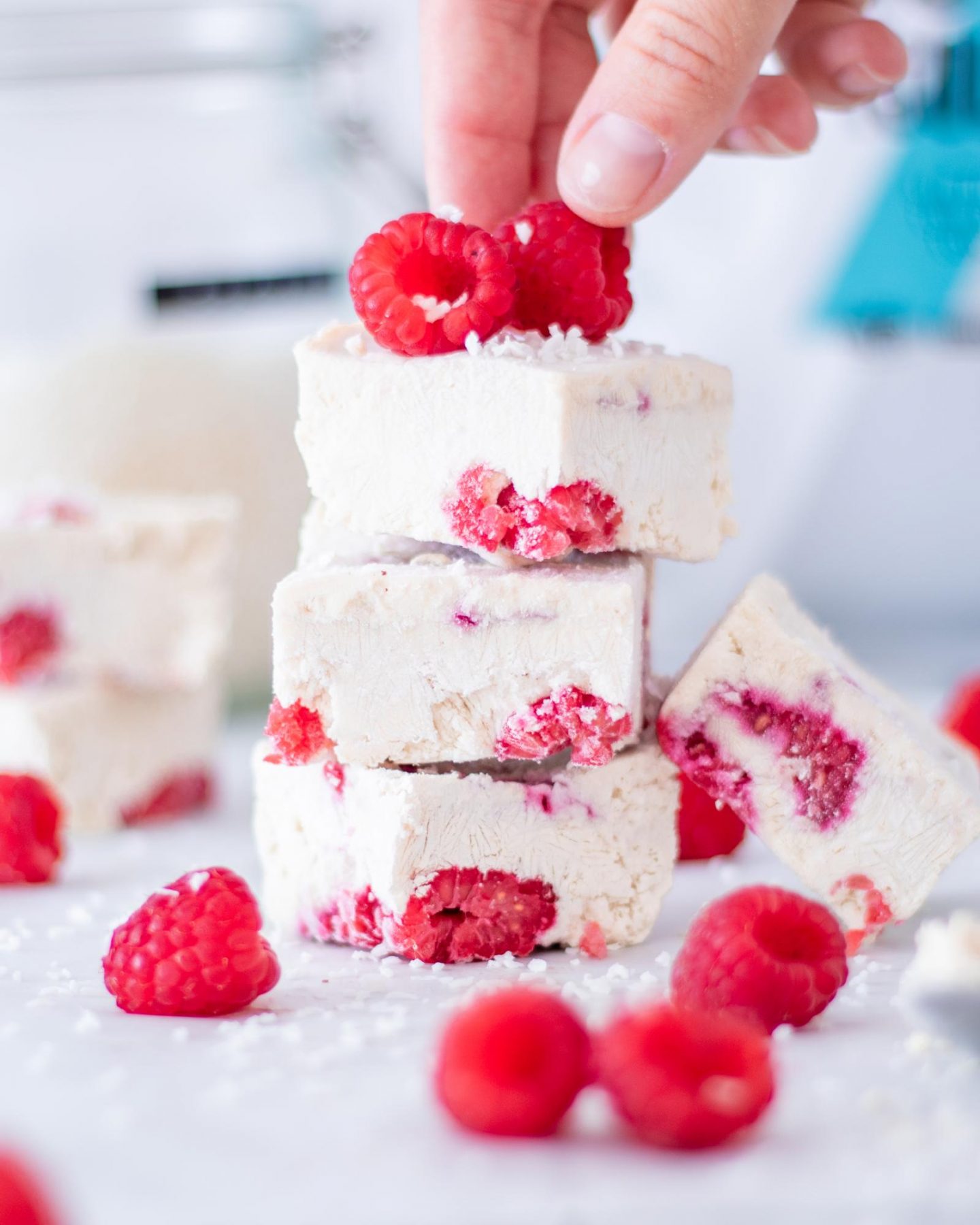 3 Vegan Protein Frozen Yogurt Bars stacked on top of each other with fresh raspberries on top