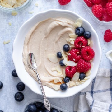 Vegan Protein Cheesecake Pudding in a white bowl with fruit on top