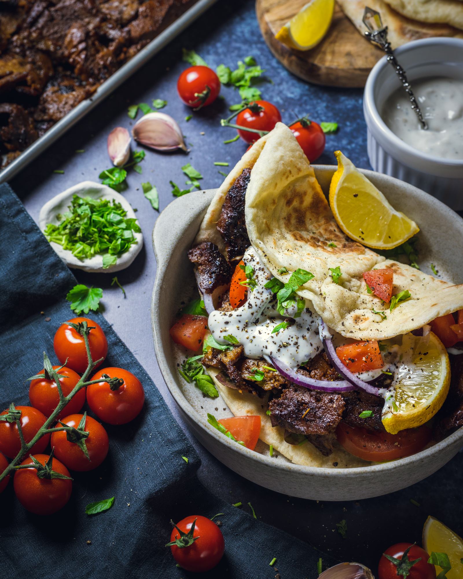 A homemade vegan Doner kebab is served filled with Seitan kebab meat, fresh tomatoes, lettuce and red onion in a pitta.