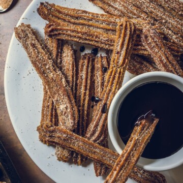 Baked Vegan Churros on a plate with vegan chocolate dip