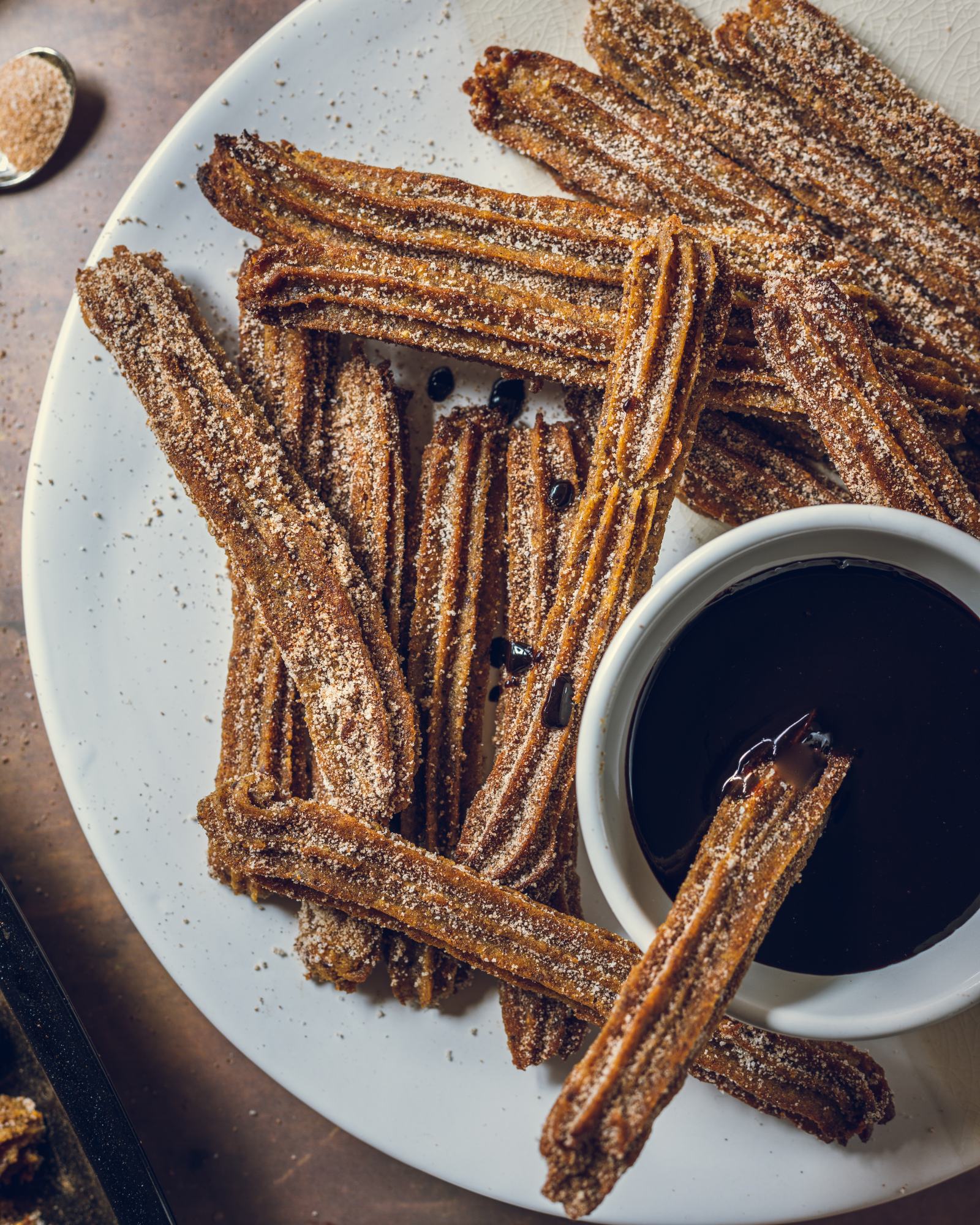 a plate filled with Baked Vegan Churros and chocolate dip