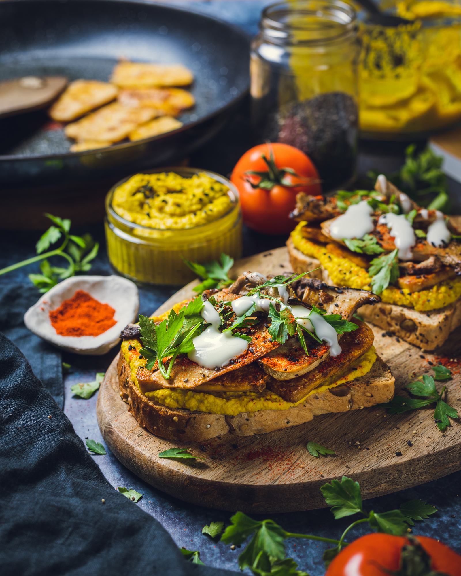 Slices of curried hummus sandwiches with tofu and mushrooms on a serving platter.