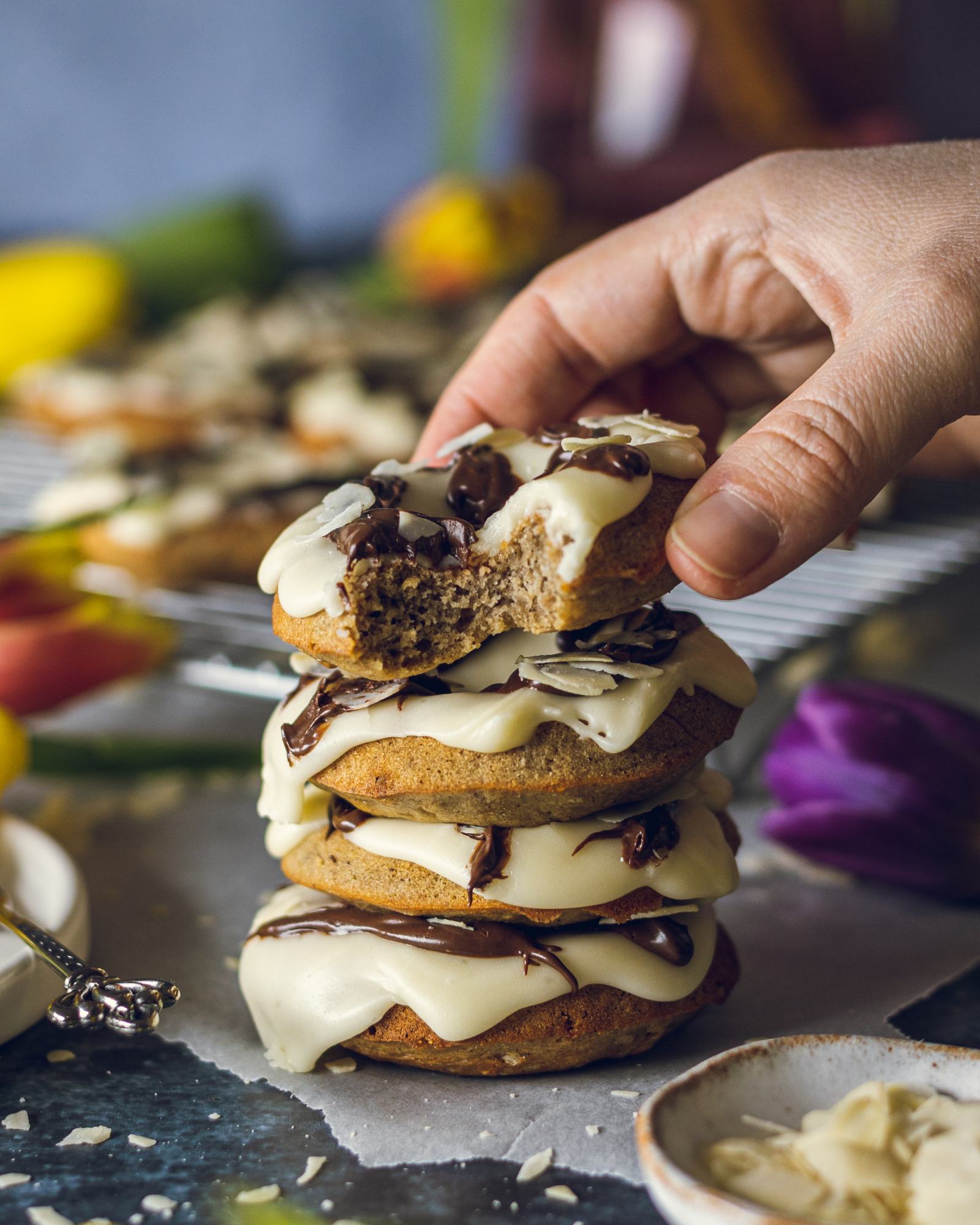 A hand grabbing a Vegan Buttermilk Doughnut from a stack