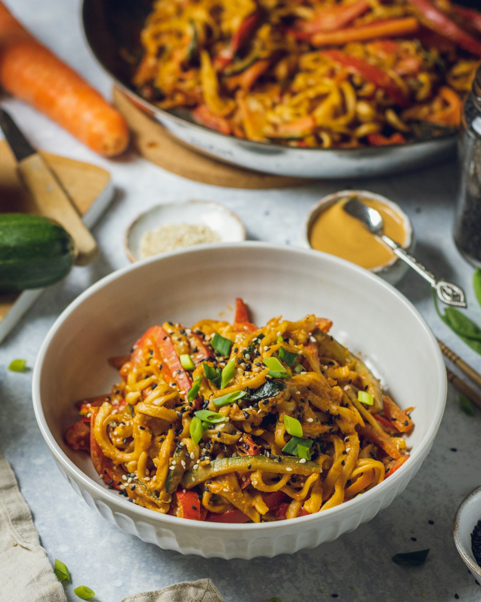 a white bowl on a dinner table filled Vegan Peanut Noodles