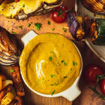 Pineapple Curry BBQ Sauce in a small bowl next to grilled skewers