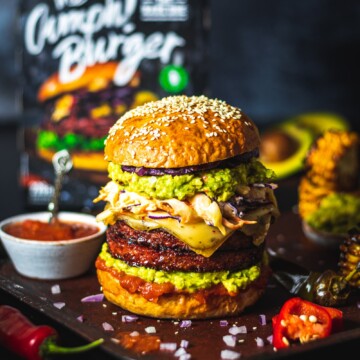 A vegan burger made with homemade vegan burger buns and two patties on a dark table