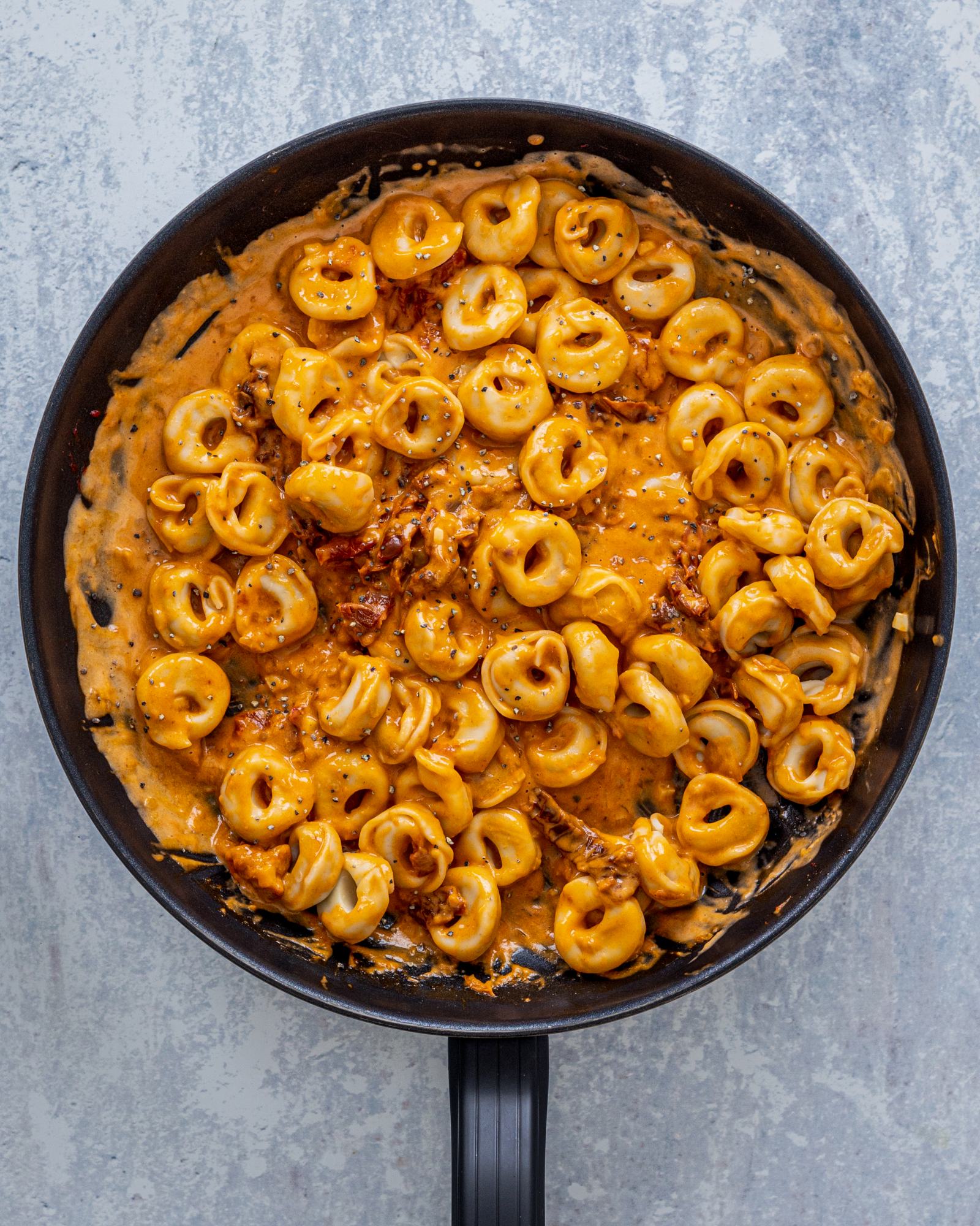 Creamy Sun-Dried Tomato Pasta - Vegan Tortellini in a pan, photographed from above