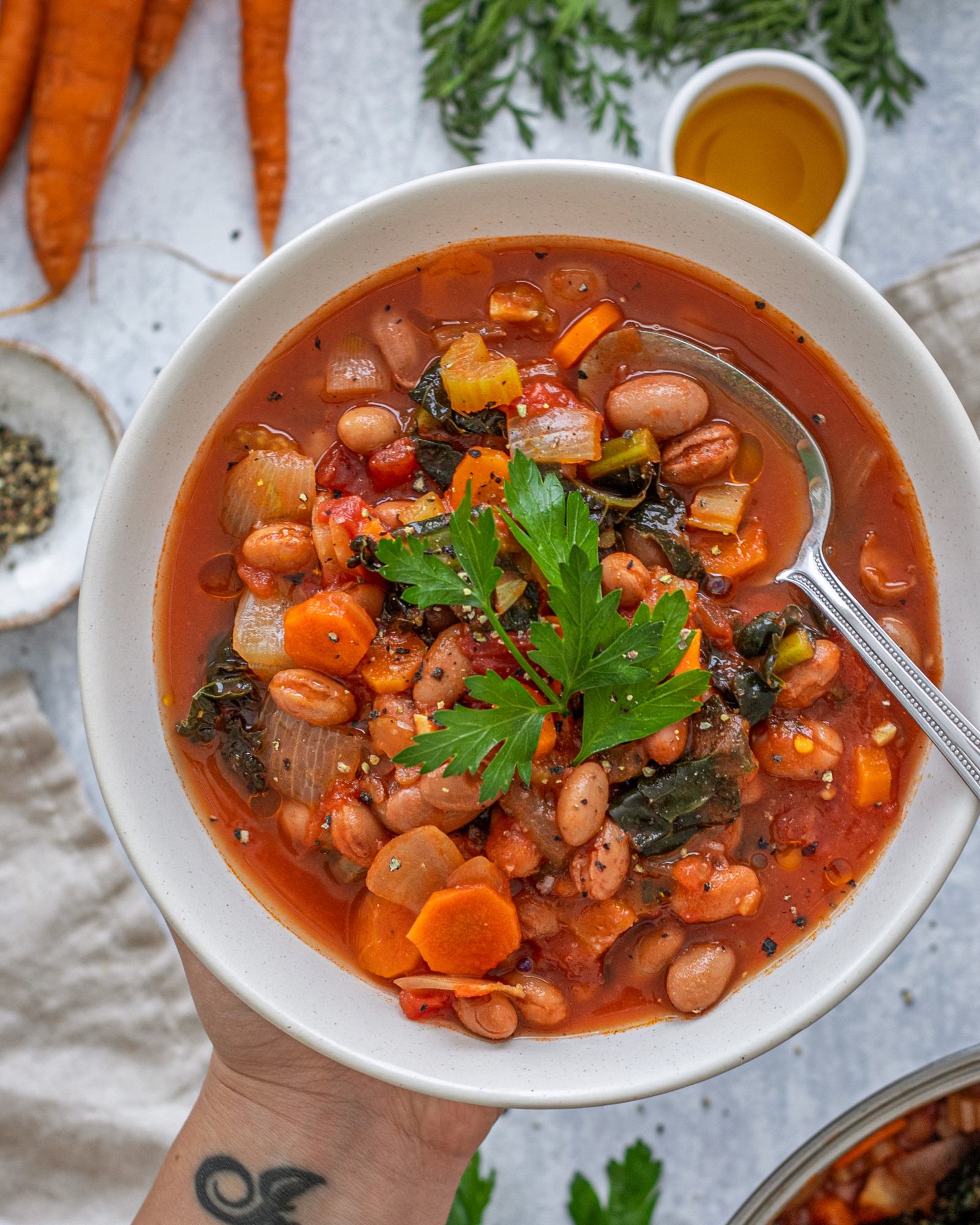 Kale and Borlotti Bean Soup in a bowl with a spoon