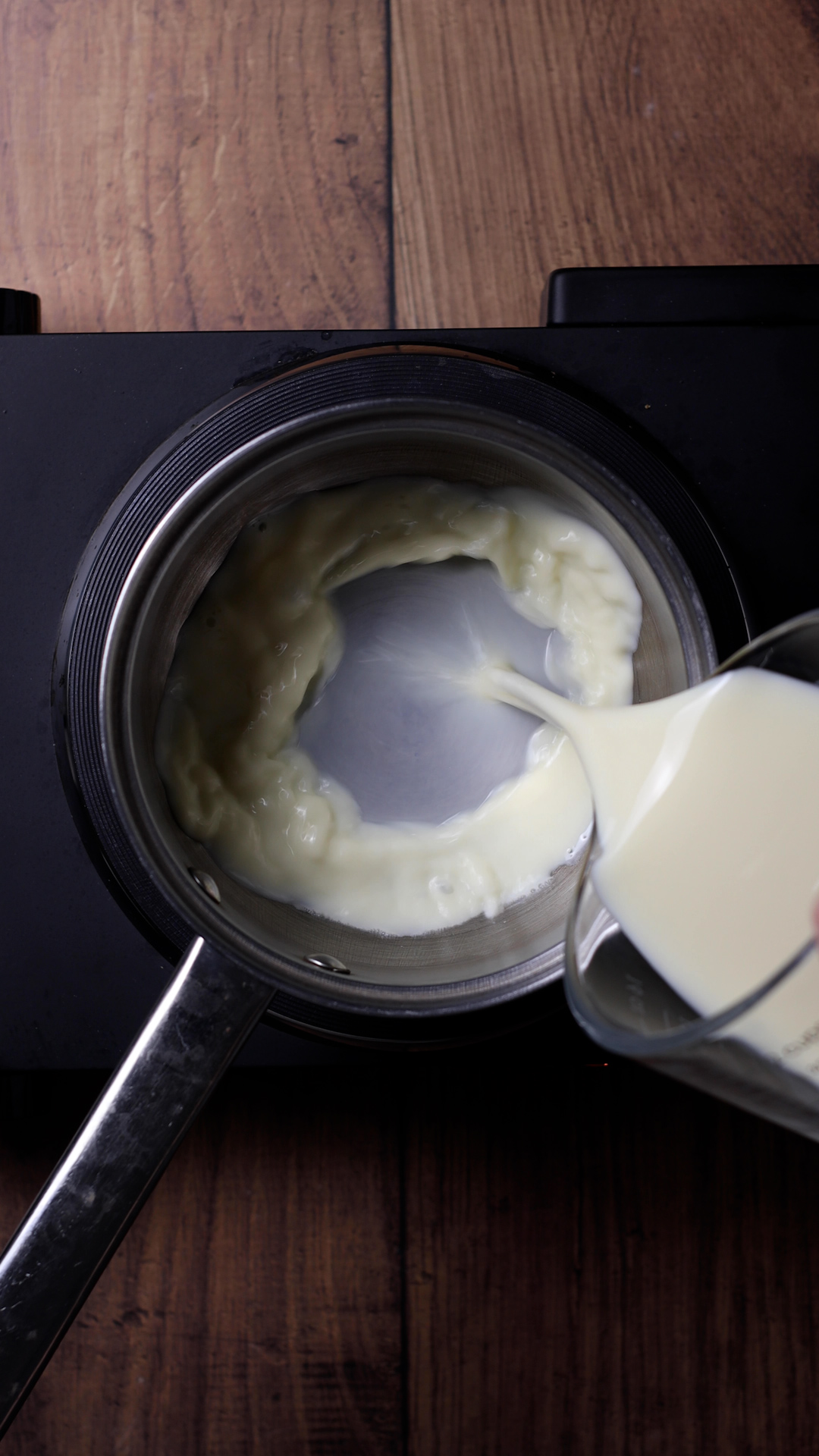 Milk being poured into a saucepan.