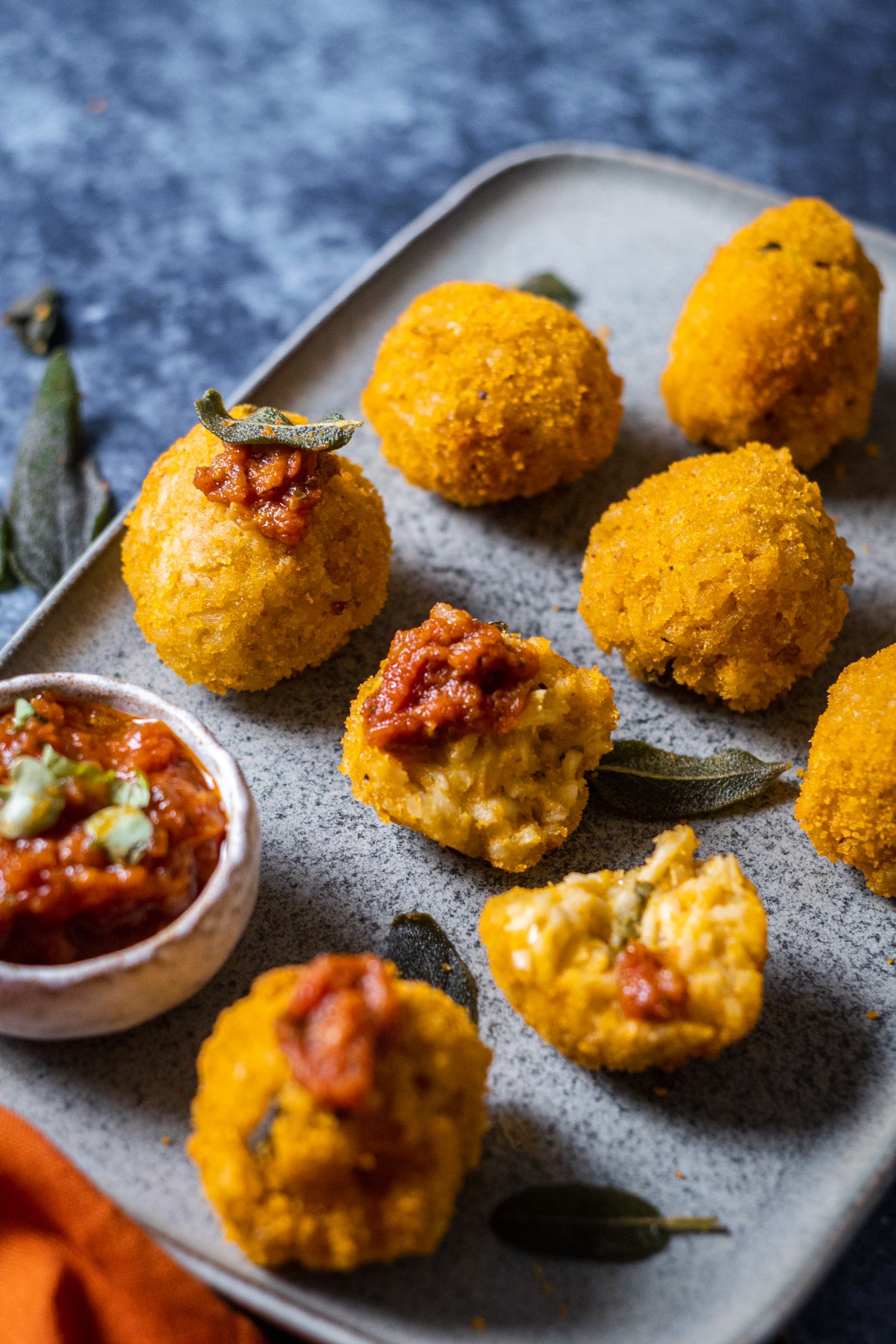 pumpkin arancini next to each other on a blue serving platter