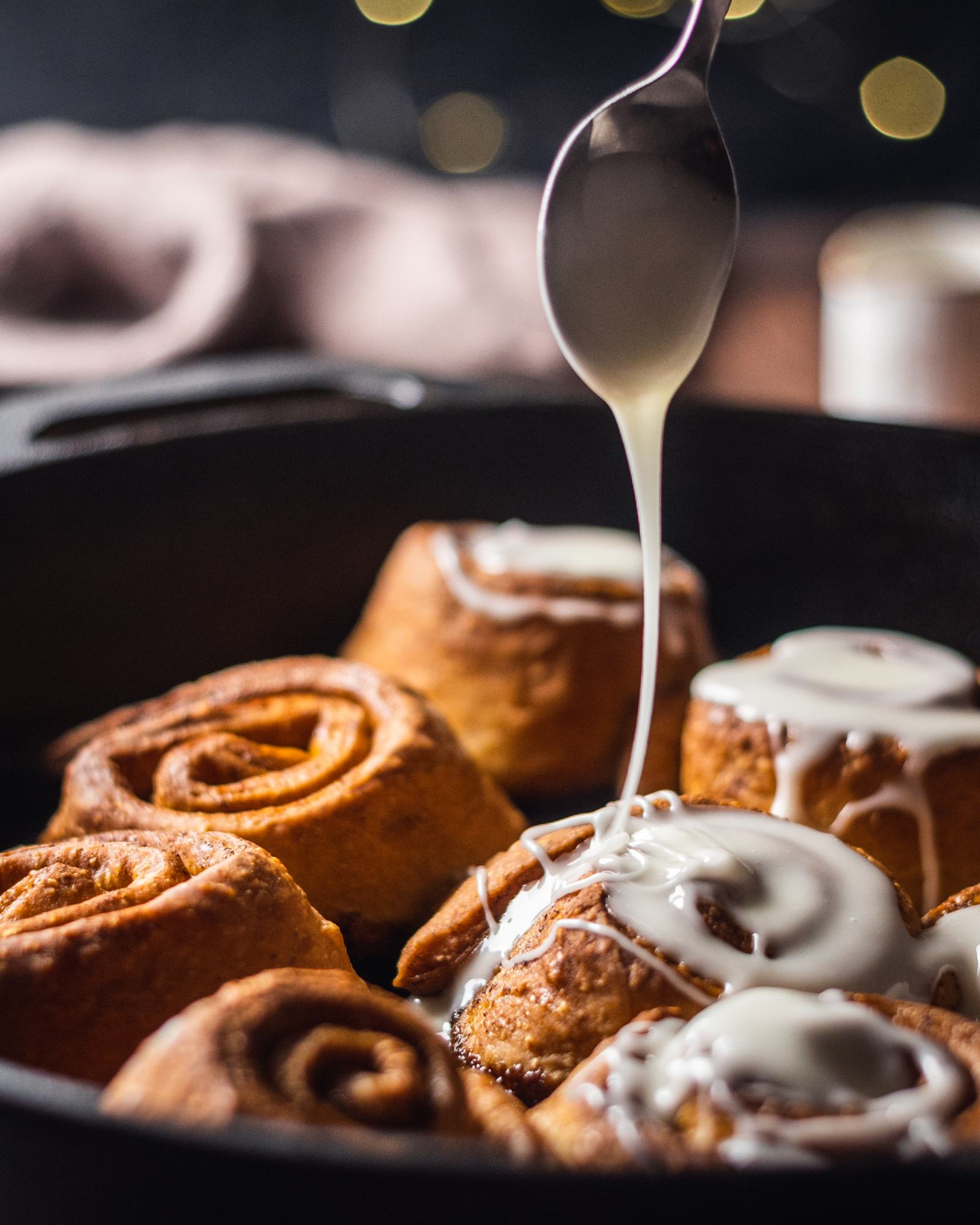 Easy Vegan Cinnamon Rolls photographed from the side with glaze drizzling onto the cinnamon rolls
