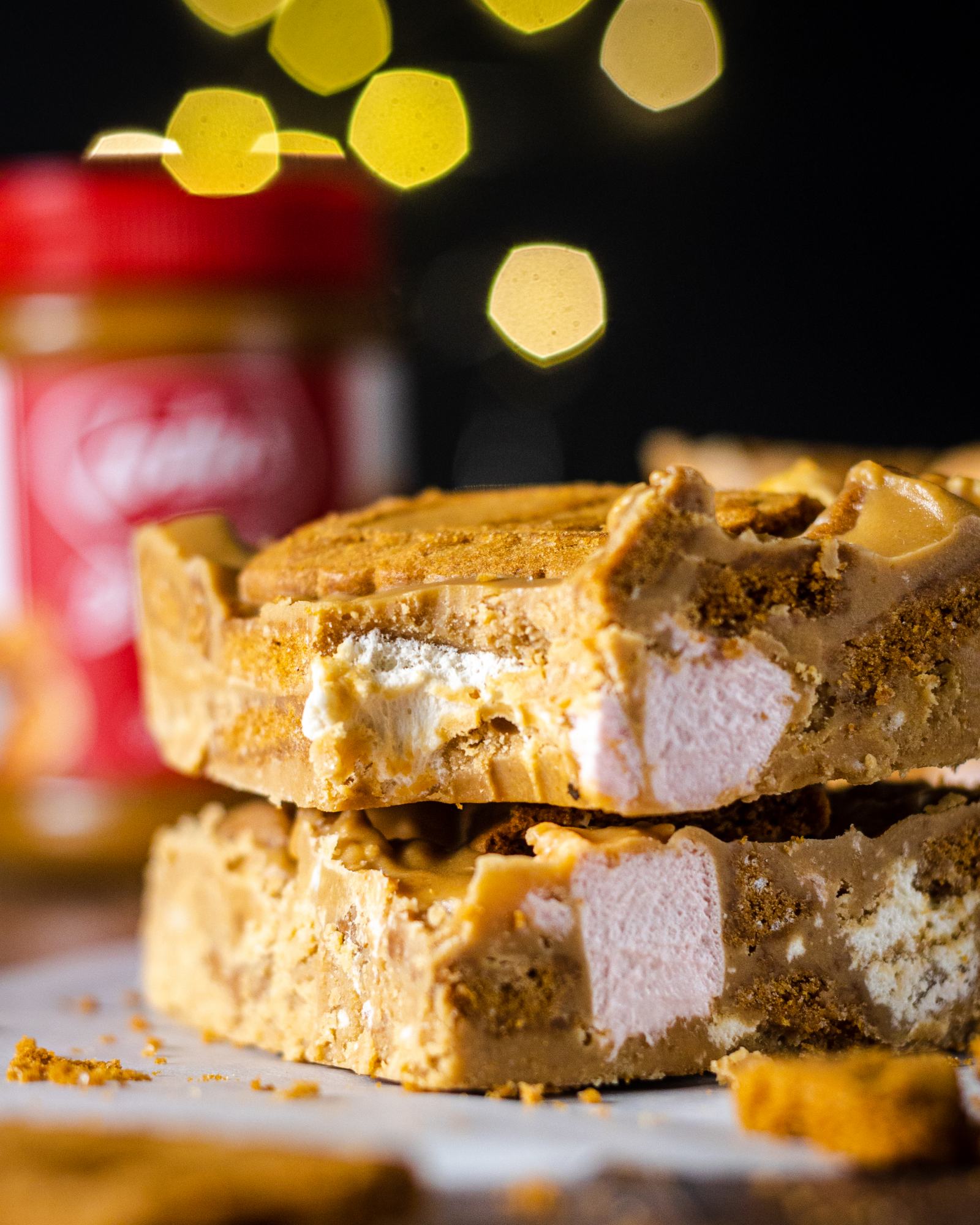 A close up of two biscoff rocky road bars with a bite taken out of the top one, looking delicious and mouth-watering!