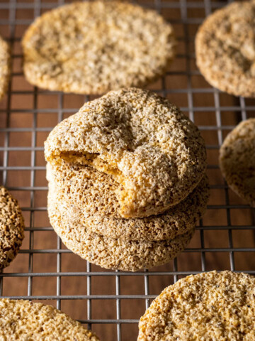 German macaroons on a cookie tray with a stack in the middle, a bite taken out of the top cookie