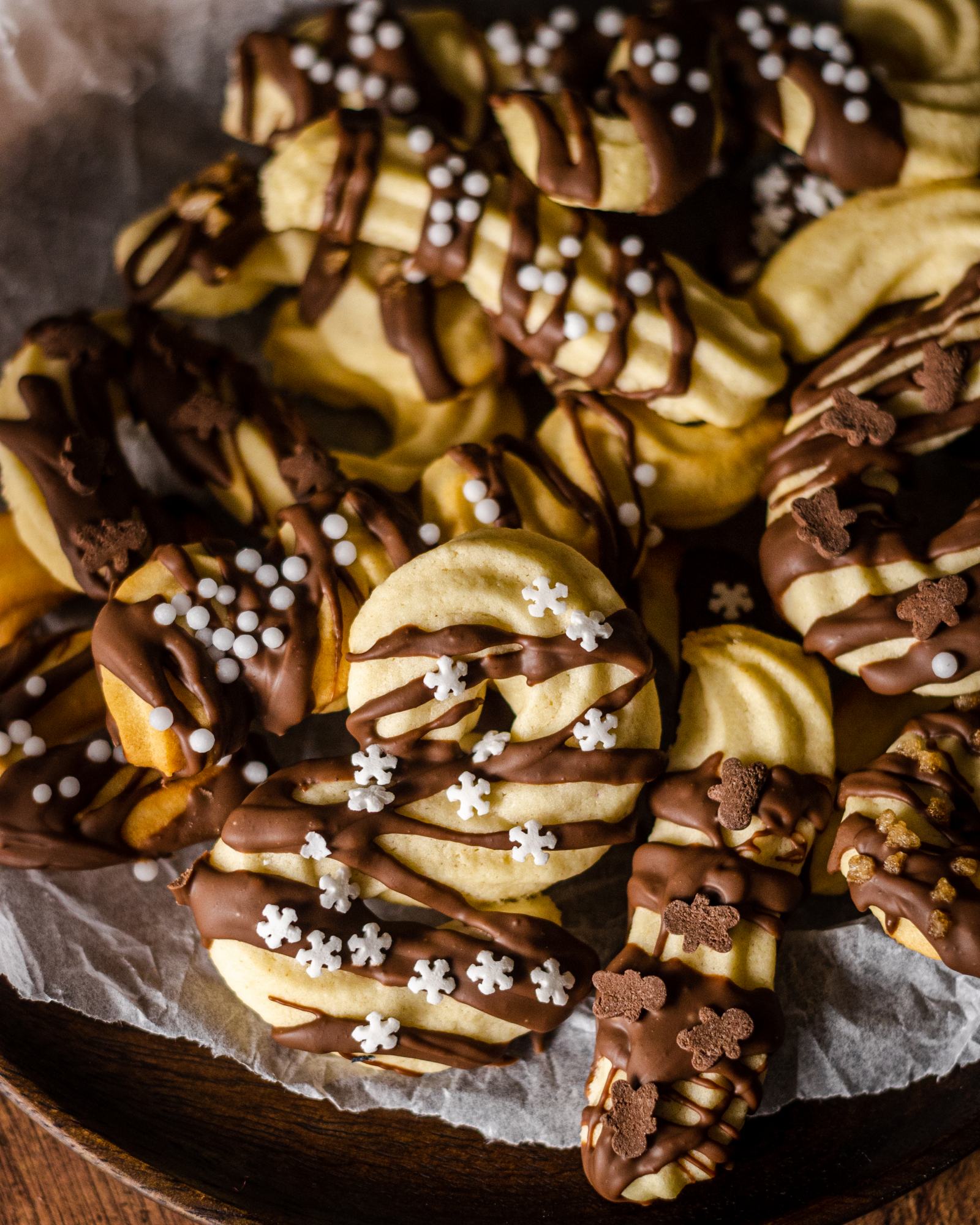 vegan Christmas cookies covered in chocolate and sprinkles on a plate