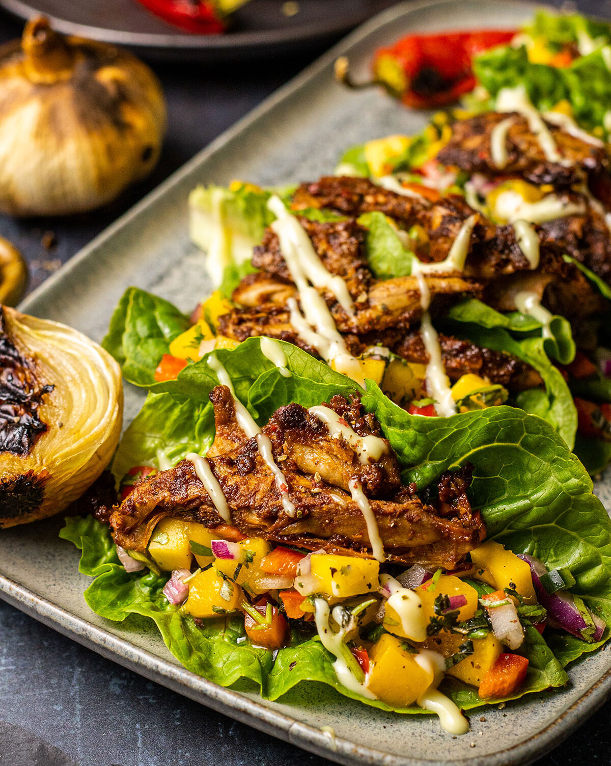 vegan lettuce wraps filled with chicken style pieces and mango salsa on a serving platter