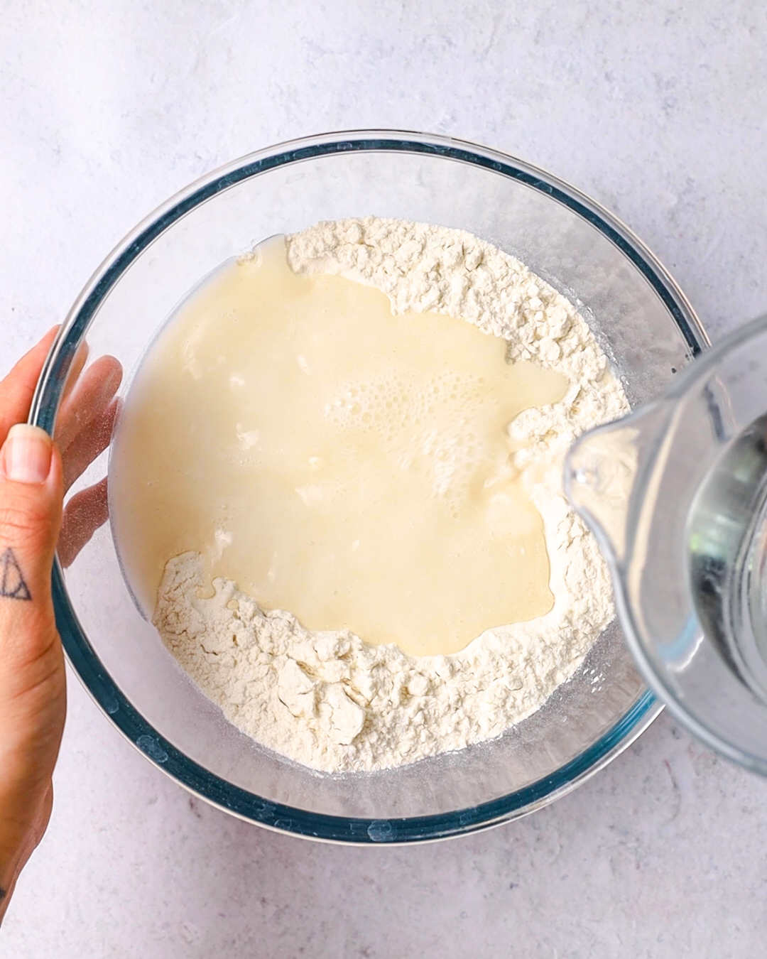 liquids poured into a bowl of flour