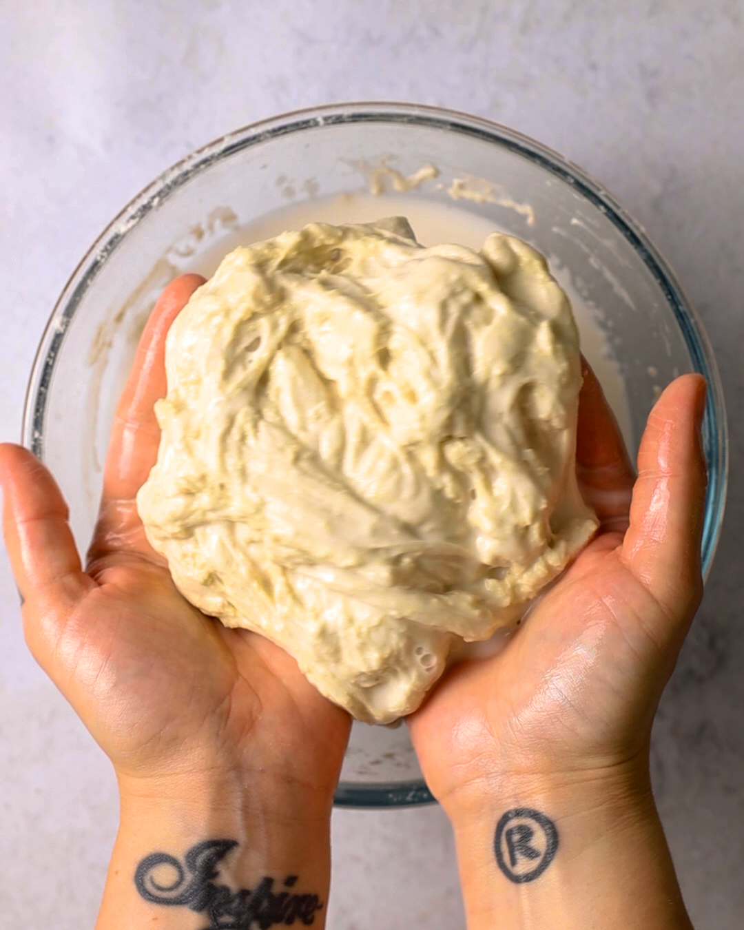 hands holding a washed flour dough ball