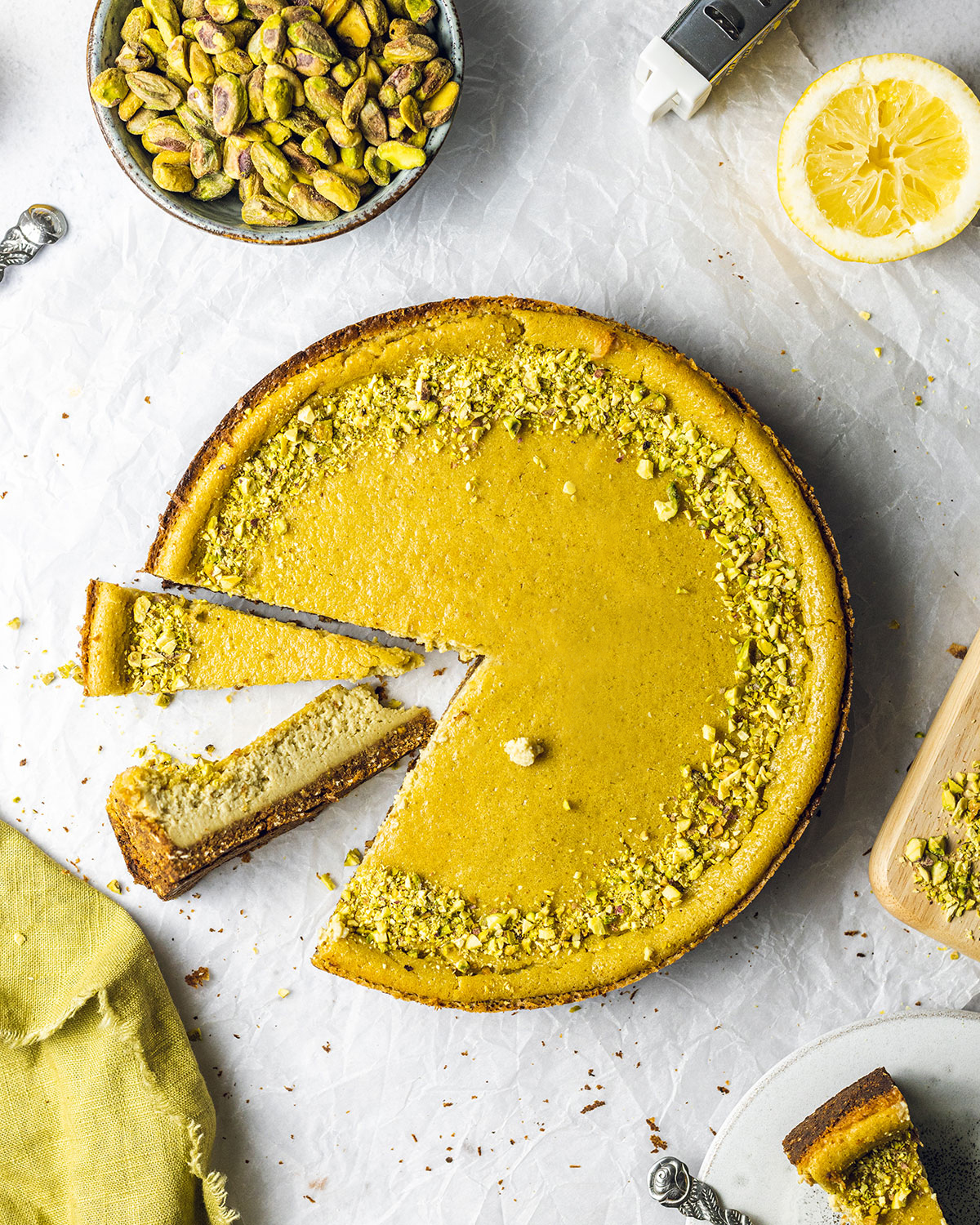 Baked pistachio cheesecake photograph from above with two slices cut out of it