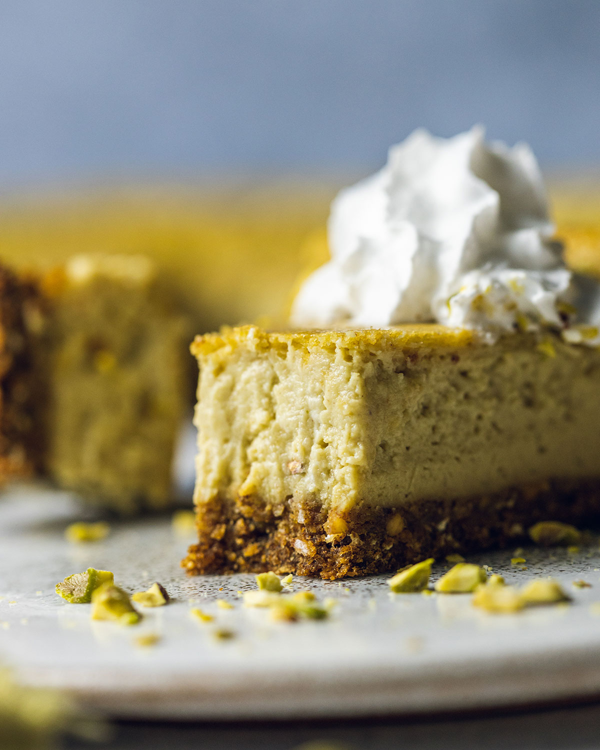 a slice of baked Vegan pistachio cheesecake with a bite taken out of it