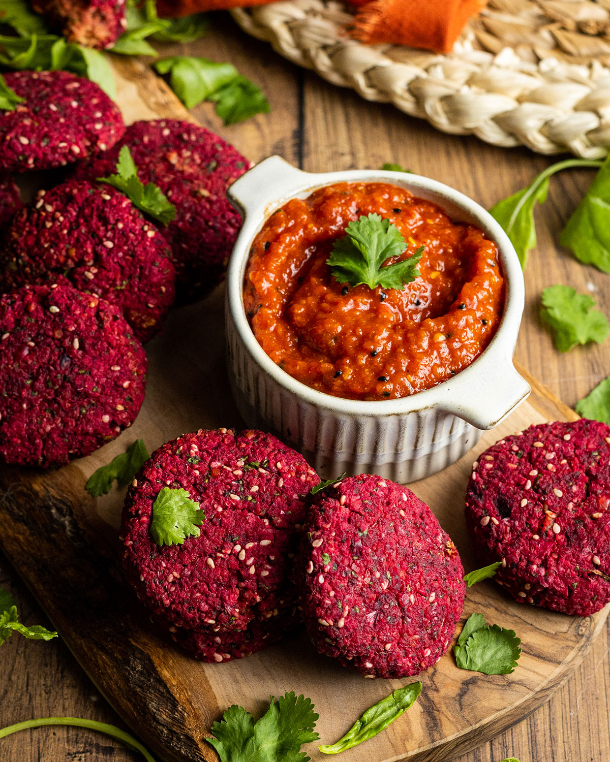 beetroot falafel on a wooden board with harissa paste on the side