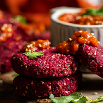 homemade vegan beetroot falafels stacked on a wooden serving board