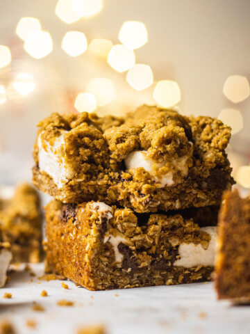 vegan baked oatmeal bars sitting on a stack with a bite taken out of the top