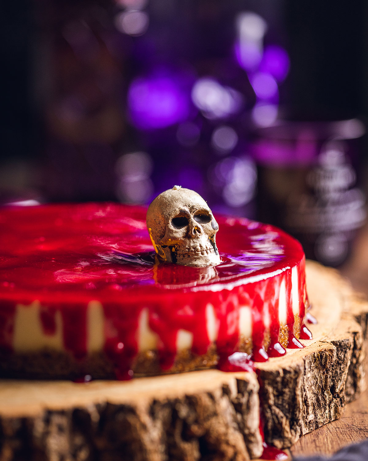 the finished halloween cheesecake complete with mini skull and glaze that resembles blood