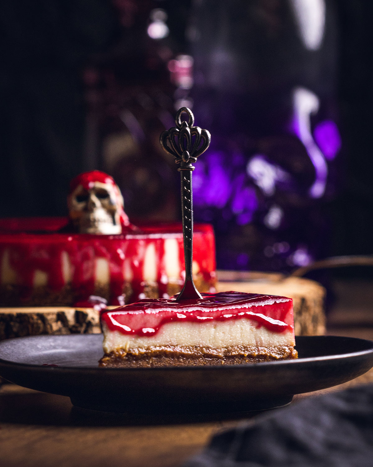 a slice of the halloween cheesecake on a black plate with a fork on top