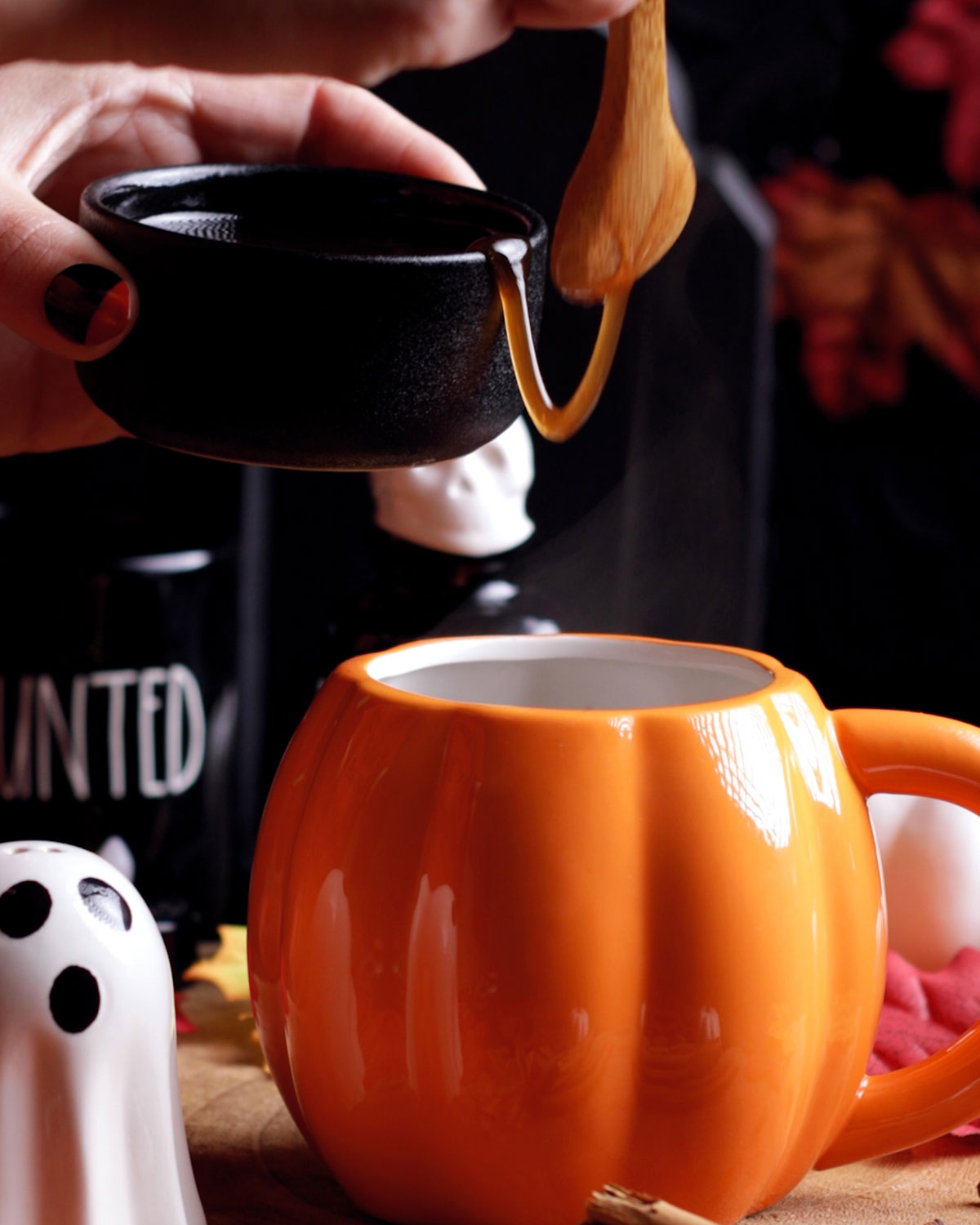 a spoon lifting the syrup out of a small bowl and into a mug