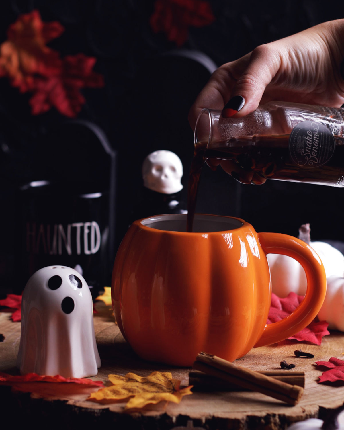 a hand pouring coffee into the pumpkin shaped mug