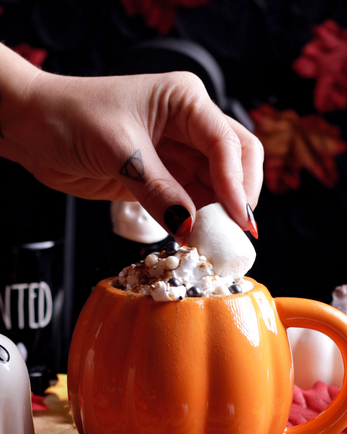 a hand adding a vegan marshmallow onto the drink