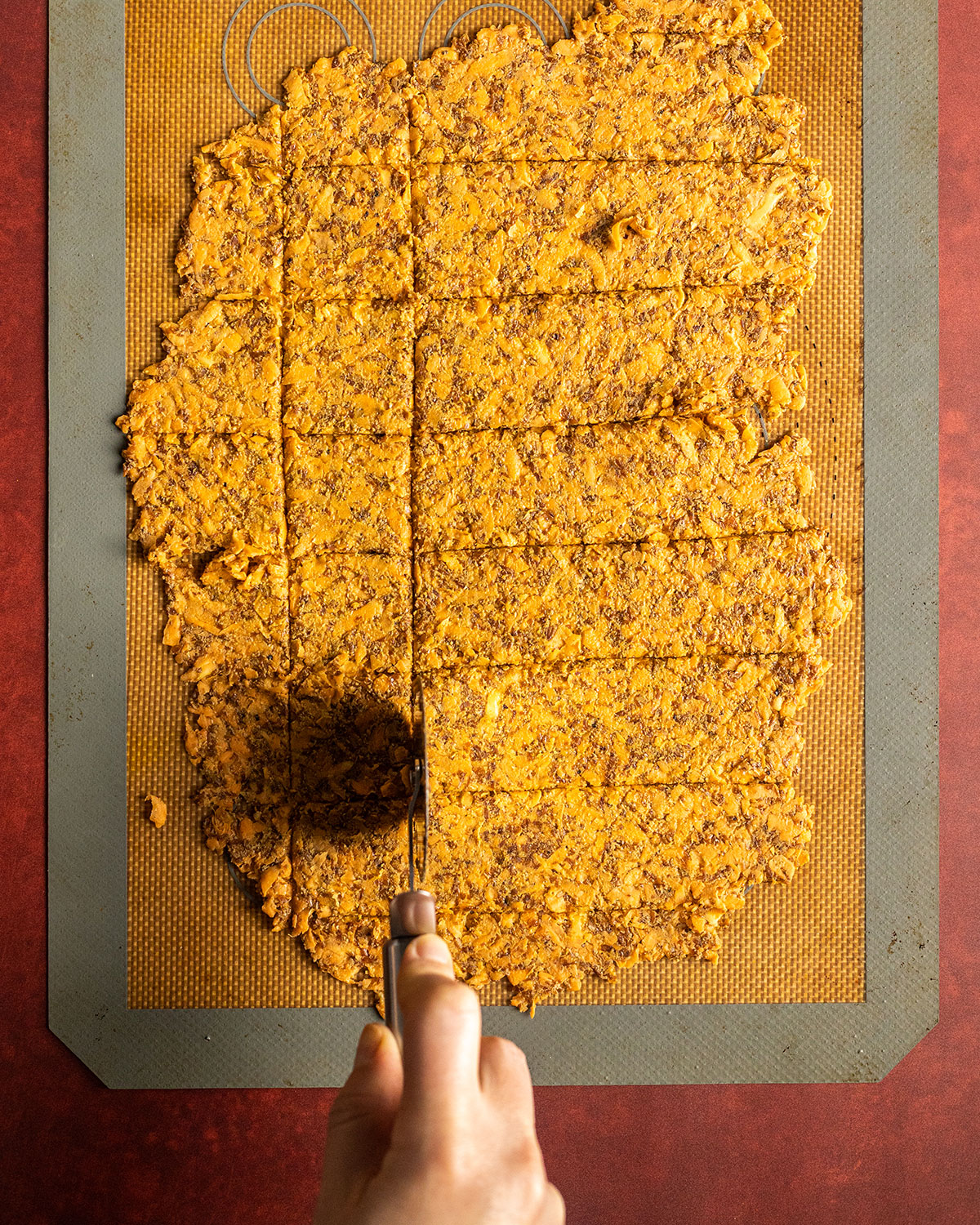 creating parallel lines across the cracker dough with a pizza cutter for square crackers