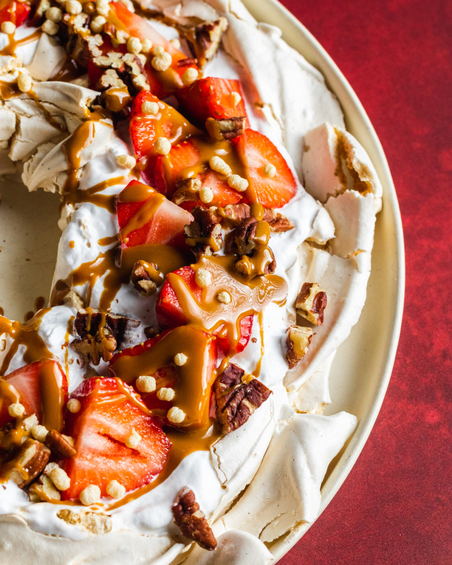 Vegan pavlova with whipped coconut cream, strawberries, nuts and peanut butter on top 