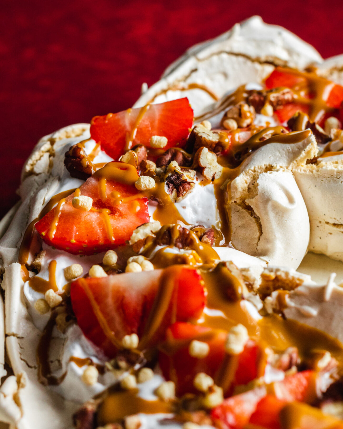 Vegan pavlova with whipped coconut cream, strawberries, nuts and peanut butter on top 