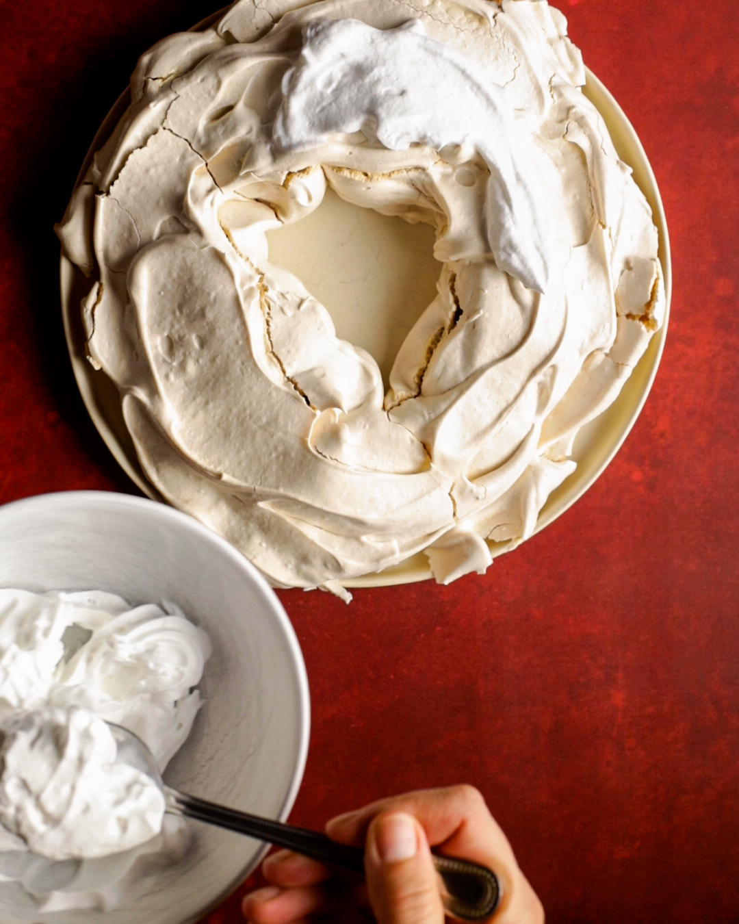 whipped cream about to be added to the pavlova wreath