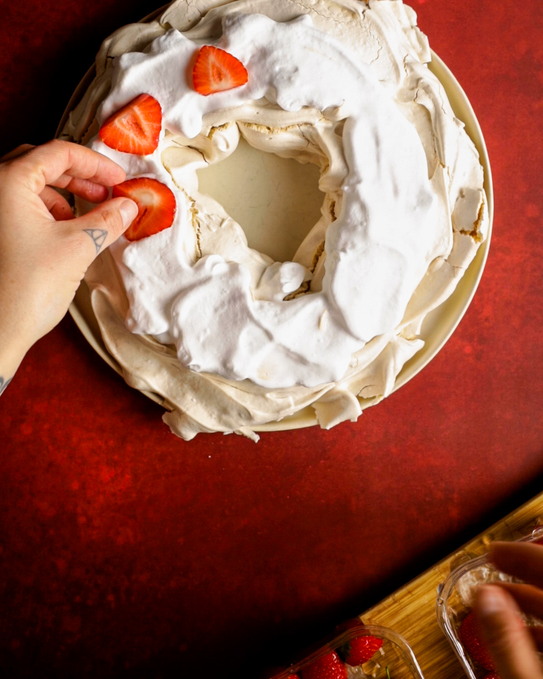 strawberries being placed on top of the whipped cream