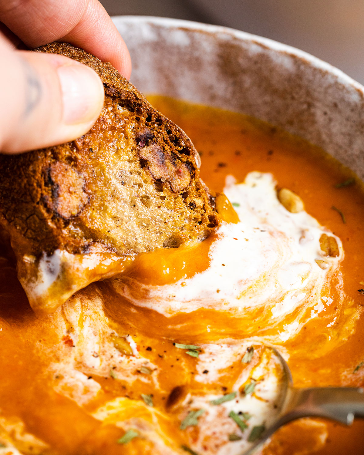 bread dipped into sweet potato soup