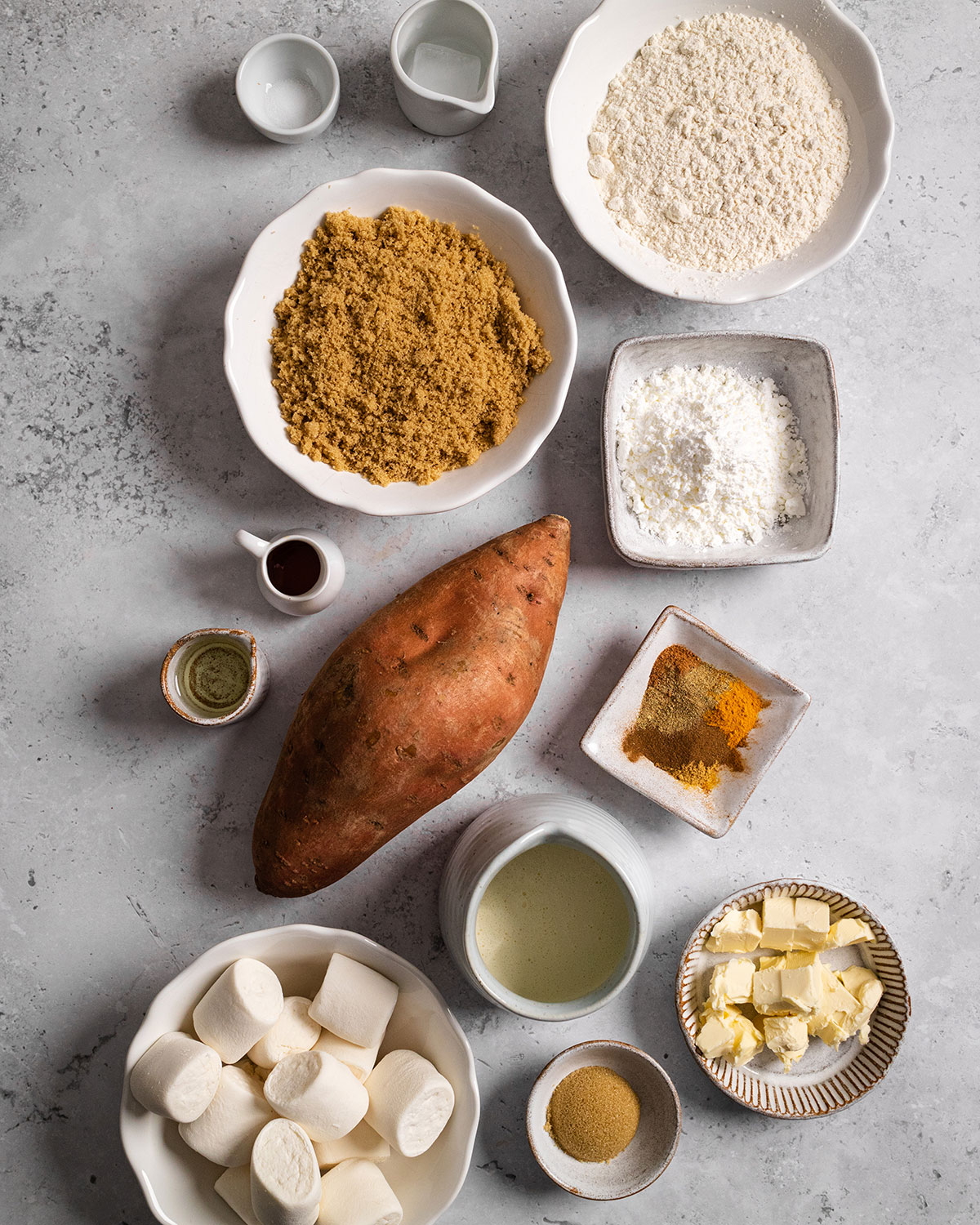 All of the ingredients needed to make a vegan sweet potato pie on a white backdrop