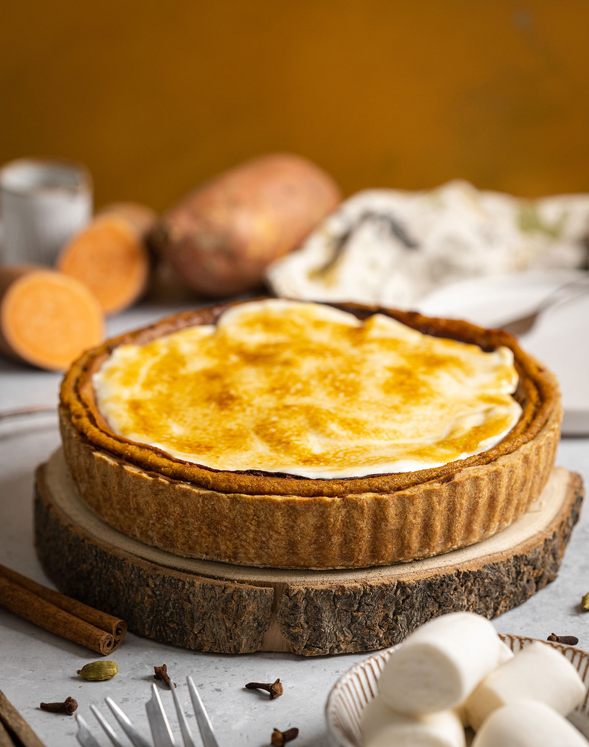 a whole round sweet potato pie on a wooden serving dish