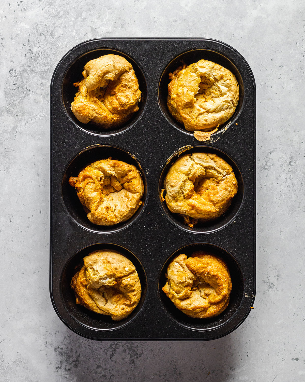 Big muffin tray with six muffin holes filled with vegan Yorkshire puddings