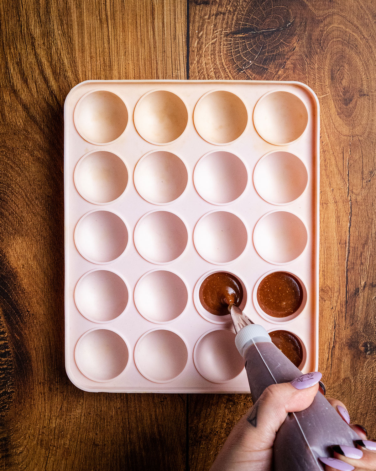 Mushroom and hazelnut cream being piped into a silicone tray