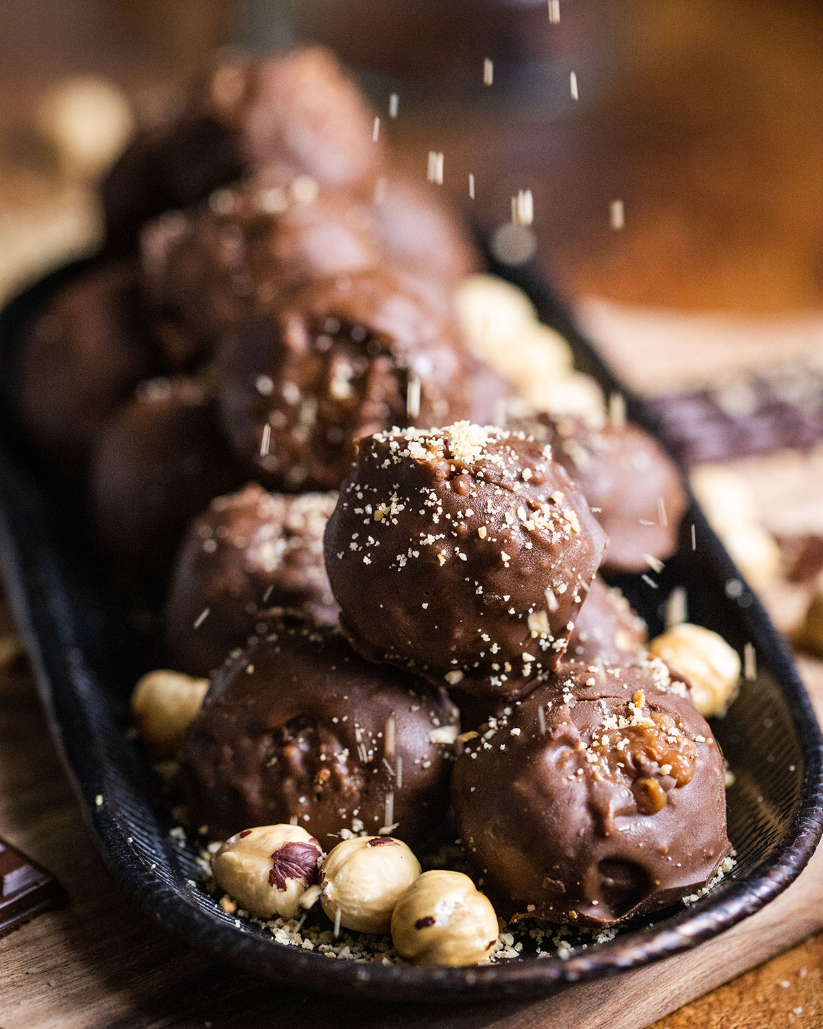 A small plate filled with vegan Ferrero Rocher made with hazelnuts and vegan chocolate to a gluten-free recipe with only six ingredients